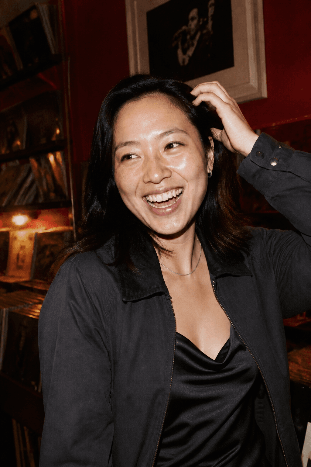 A woman laughing in a record bar
